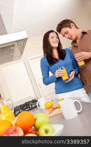 Young man and woman drinking orange juice in the kitchen