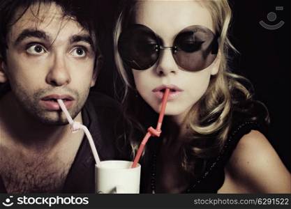Young man and woman drinking through a tube