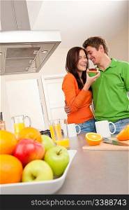 Young man and woman eating toast together in the kitchen