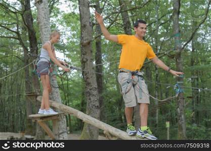 young man and woman having fun in the trees