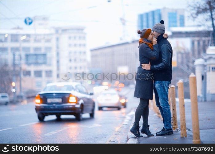 young man and woman hugging kissing outside