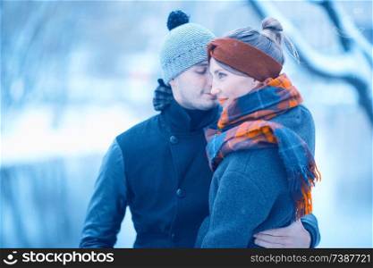 young man and woman hugging kissing outside
