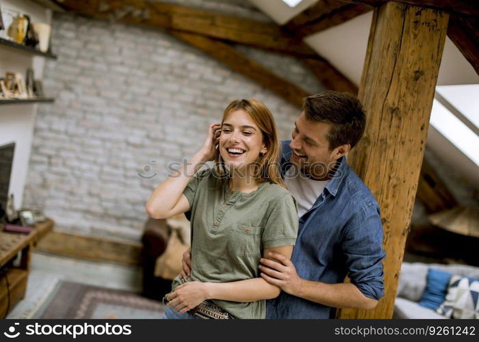 Young man and woman hugging standing at home interior and tender husband embracing wife gently