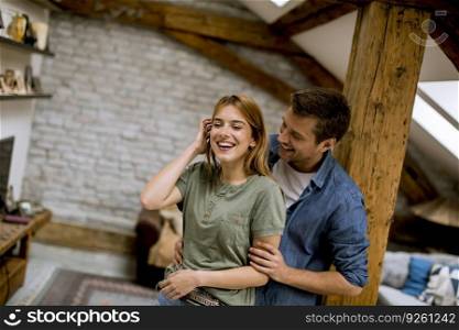 Young man and woman hugging standing at home interior and tender husband embracing wife gently