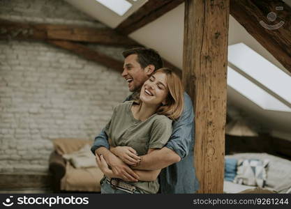 Young man and woman hugging standing at home interior and tender husband embracing wife gently