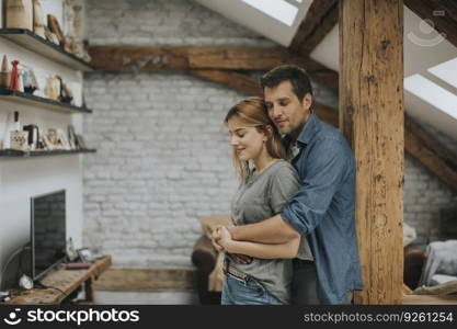 Young man and woman hugging standing at home interior and tender husband embracing wife gently