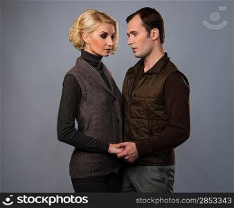Young man and woman in casual brown wear isolated on grey background