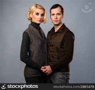Young man and woman in casual brown wear isolated on grey background