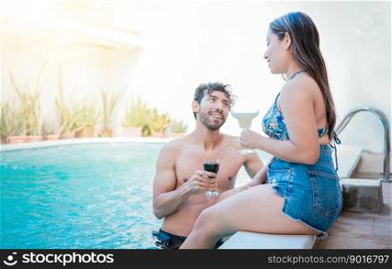 Young man and woman on vacation toasting in the pool. Young couple on vacation toasting and talking in swimming pool, Smiling couple toasting in swimming pool