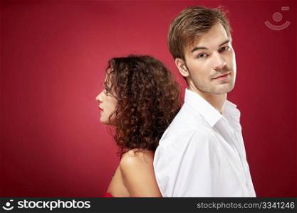 Young man and woman stand a back to each other