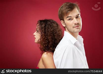 Young man and woman stand a back to each other