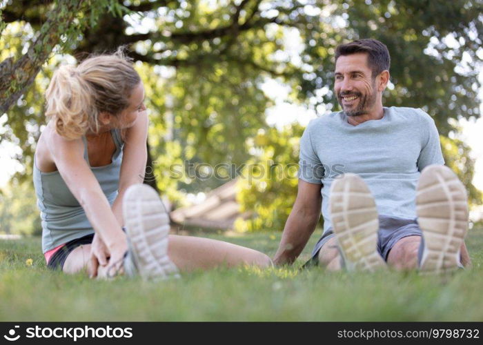 young man and woman stretching before running