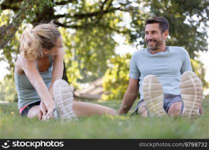 young man and woman stretching before running