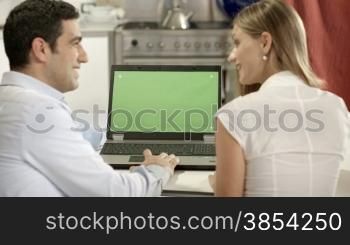 Young man and woman using laptop pc with green screen for internet and email. Dolly shot