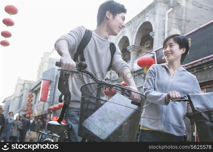 Young man and woman with bicycles and map.