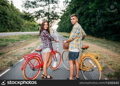 Young man and woman with retro bikes. Couple on vintage bicycles. Old cycles, romantic date