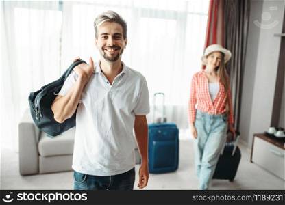 Young man and woman with suitcases went on a journey. Fees on vacation concept. Luggage preparation. Travelling or tourism. Man and woman with suitcases went on a journey
