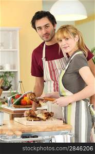 Young man and young woman cutting chicken