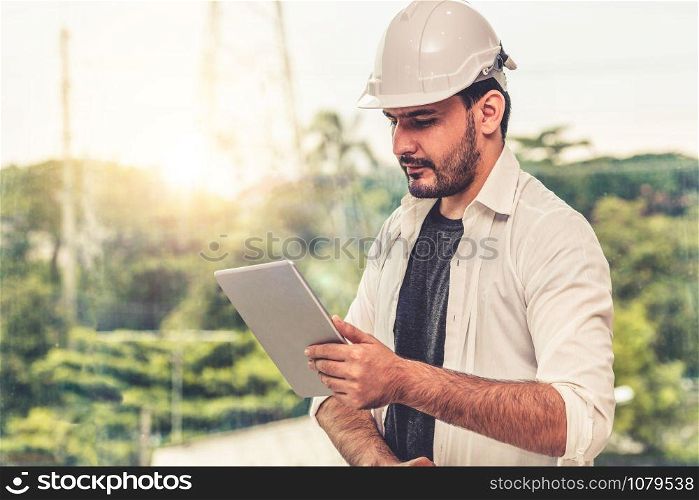 Young man architect or engineer working with tablet computer to make interior design at workplace. Real estate business and civil engineering concept.