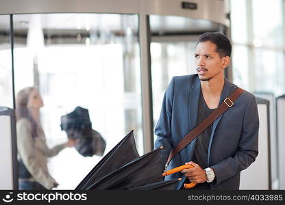 Young man arriving with umbrella