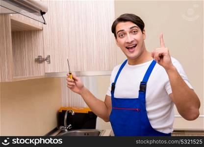 Young man assembling kitchen furniture