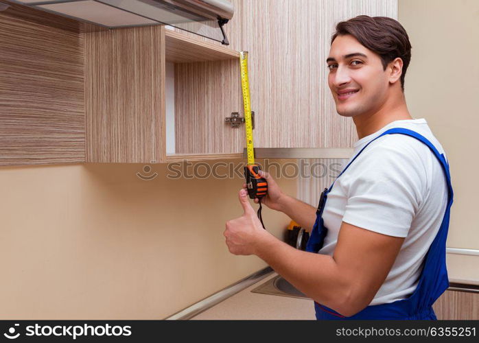 Young man assembling kitchen furniture