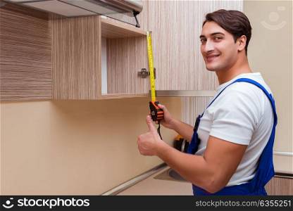 Young man assembling kitchen furniture