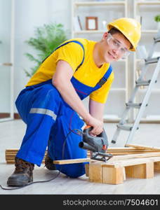 Young man assembling wood pallet. The young man assembling wood pallet