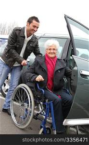 Young man assisting senior woman in wheelchair