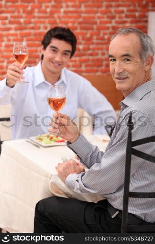 Young man at a restaurant with his grandfather