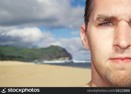 Young man at beach, close-up, portrait