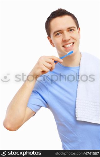 Young man at home brushing teeth in the morning