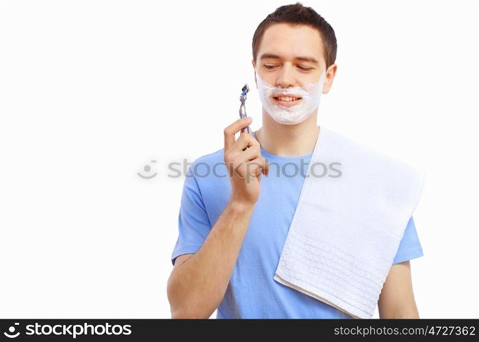 Young man at home shaving himself in the morning
