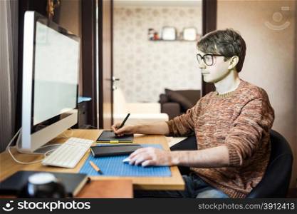 Young man at home using a computer, freelance developer or designer working at home.