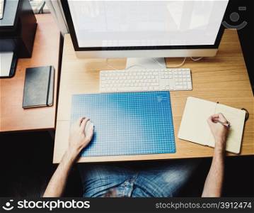 Young man at home using a computer, freelance developer or designer working at home