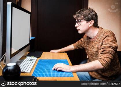 Young man at home using a computer, freelance developer or designer working at home