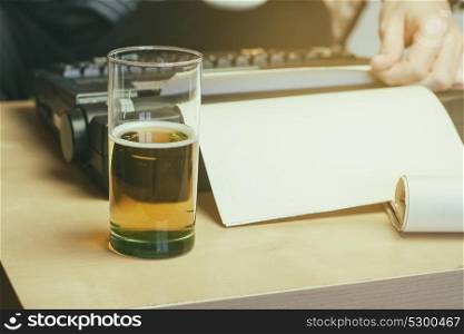 Young man at home writing something and drink beer