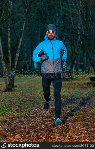 Young man athlete during a run in the woods