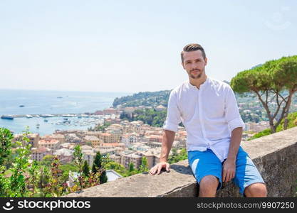 Young man background the old village take selfie. Happy young boy background the old coastal town Rapallo in Liguria