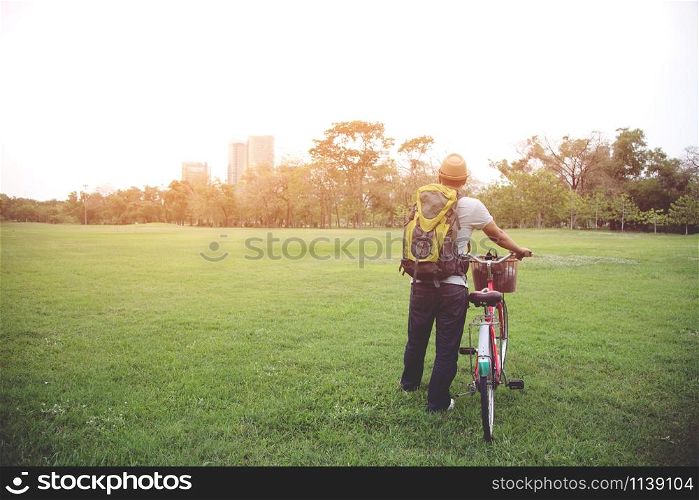 young man backpack heading to using Bicycle to travel to in city for help reduce global warming .Nature conservation concept.