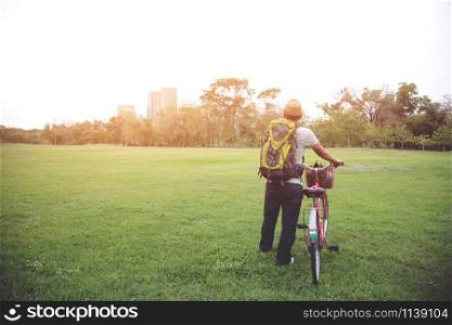 young man backpack heading to using Bicycle to travel to in city for help reduce global warming .Nature conservation concept.