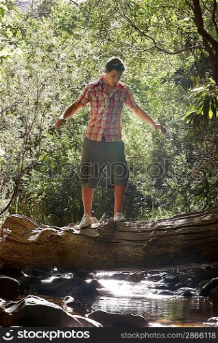 Young Man Balancing on Log
