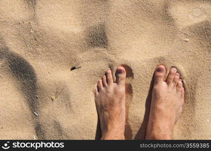 young man barefoot on a sandy beach in Algarve, Portugal