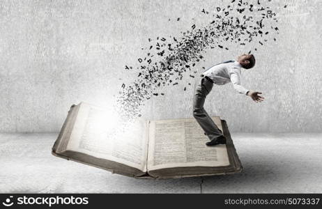 Young man benting to evade characters flying from book. Businessman evades ideas