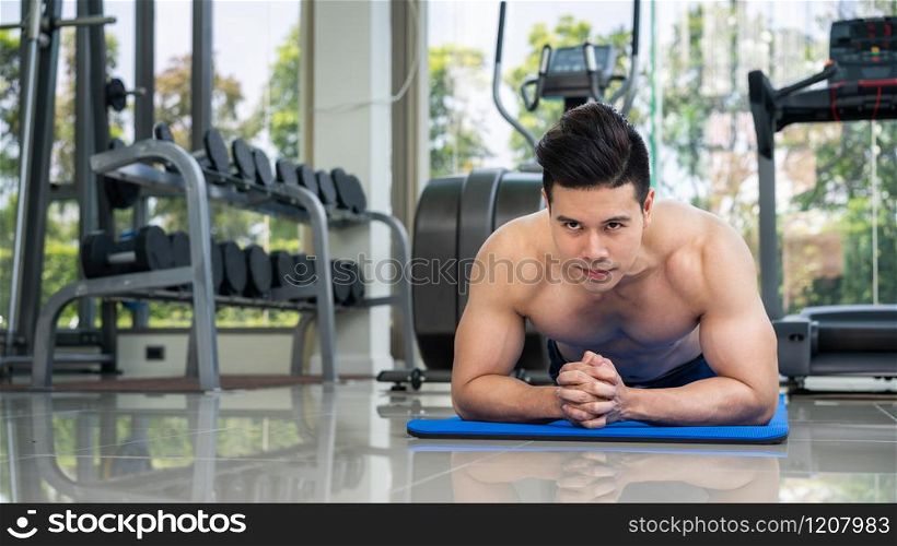 Young man bodybuilder doing push up in fitness center. Healthy lifestyle and body building concept.. Young man bodybuilder push up in fitness center.