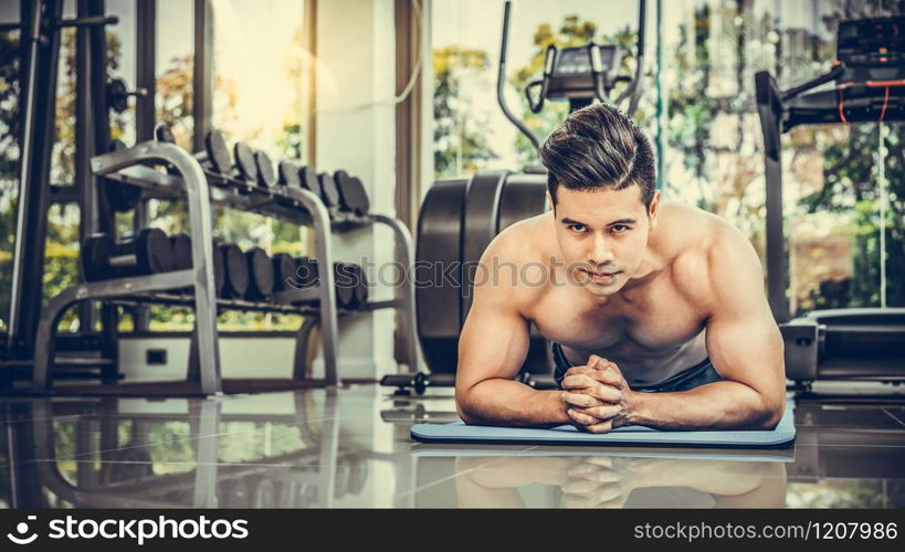 Young man bodybuilder doing push up in fitness center. Healthy lifestyle and body building concept.