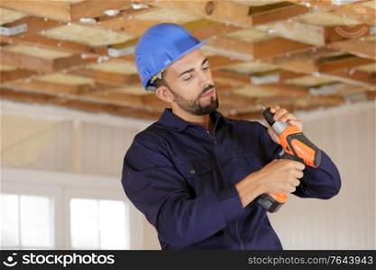 young man builder adjusting cordless drill