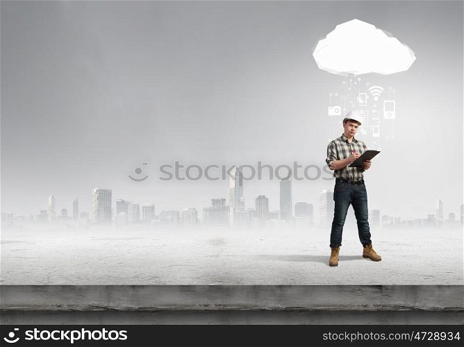 Young man builder looking thoughtfully at construction project. concept. Builder has an idea
