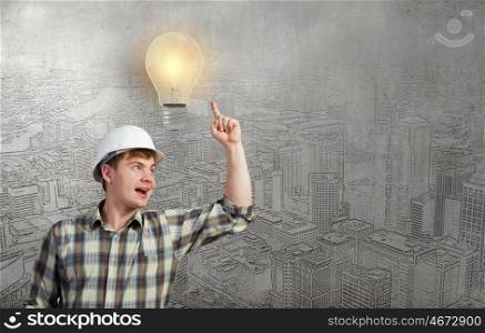 Young man builder pointing at light bulb. Idea concept