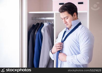 Young man businessman getting dressed for work